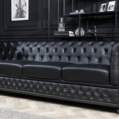 Fåtölj CHESTERFIELD i svart konstläder med knappstoppning och dekorativa nitar