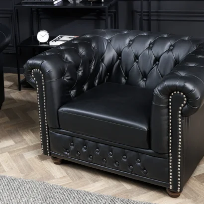 Fåtölj CHESTERFIELD i svart konstläder med knappstoppning och dekorativa nitar